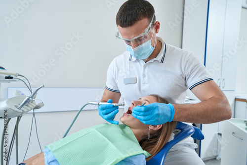 Professional dentist treating dental caries in teenager