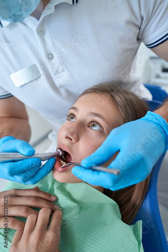 Pediatric dentist using medical equipment for treating caries in patient