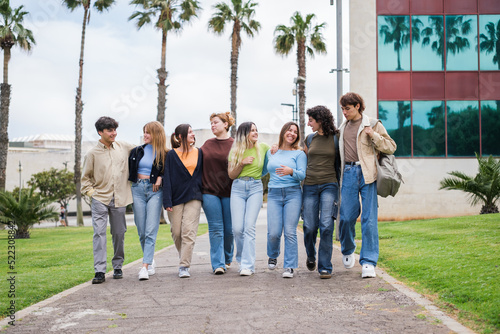 Group of young people walking through the university gardens while taking a break from studying