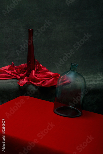 Still life with a red bottle and a glass jar