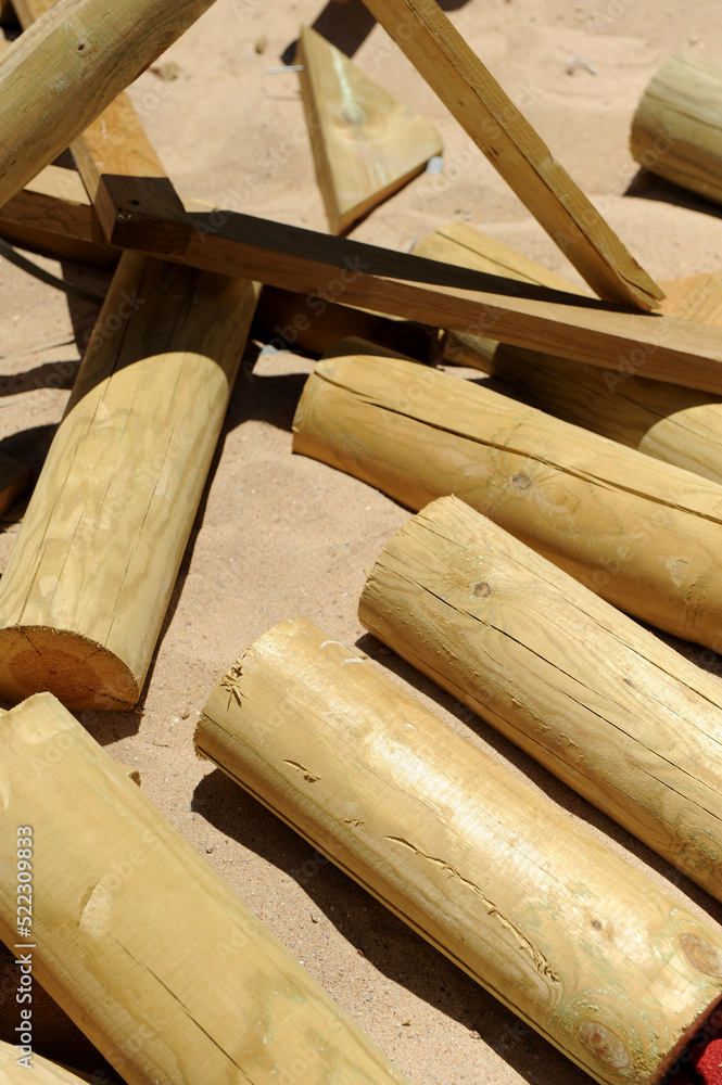 Restos de troncos de madera tratada para la contrucción de un chiringuito en la playa. Desechos de madera para reciclaje de materiales de construcción