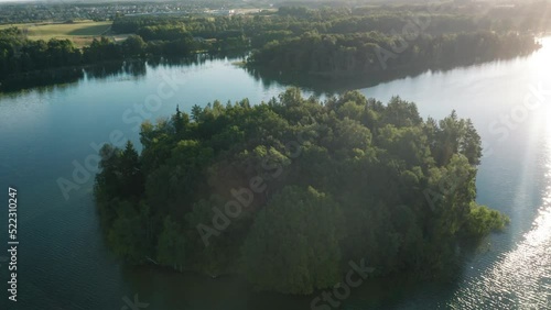 Lake island aerial view. Green small island in the middle of vast body of water. Forest isle photo