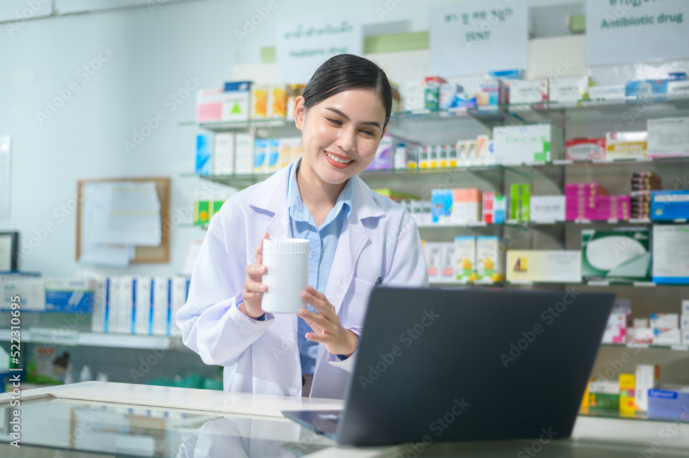 Female pharmacist counseling customer via video call in a modern pharmacy drugstore.