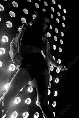 Sexy girl dance on front of spot light wall with smoke