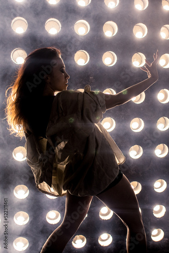 Sexy girl dance on front of spot light wall with smoke