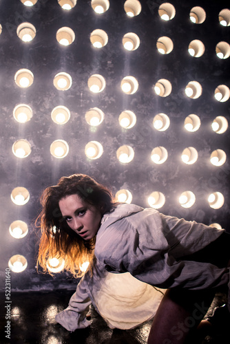 Sexy girl dance on front of spot light wall with smoke