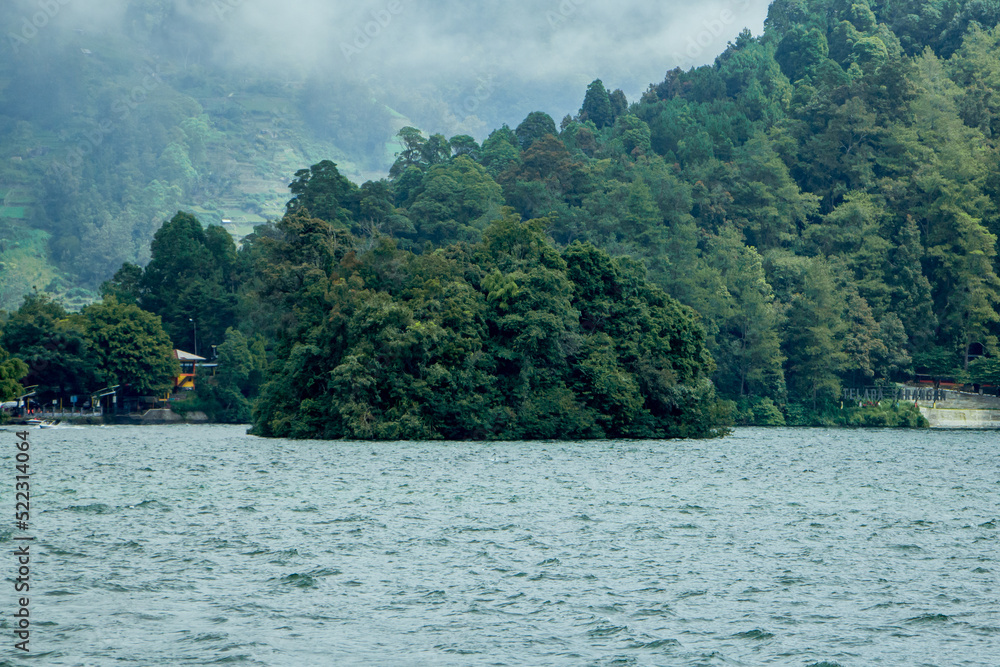 Natural panoramic portrait. Sarangan Lake with fog and boats in the morning. Natural panoramic portrait. Sarangan Lake with fog and boats in the morning.