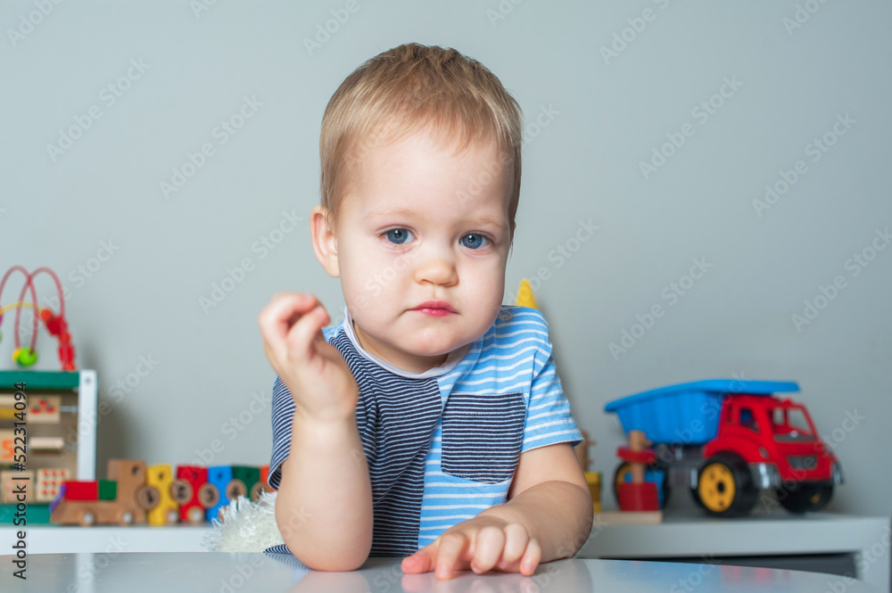 Portrait of toddler boy with facial expressions in interior of children's room at home.. Portrait of toddler boy with facial expressions in interior of children's room at home..