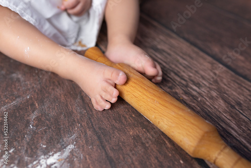 small children's feet in flour on a wooden background