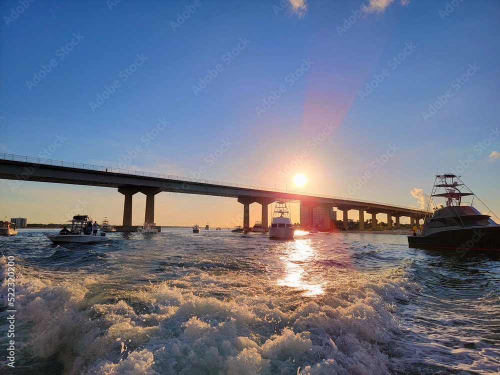 Fototapeta premium Catching Bait, passing the boats fishing for bait when leaving Perdido Pass Alabama USA to go saltwater fishing, at sunrise, sportfishing boats catching bait, Gulf of Mexico