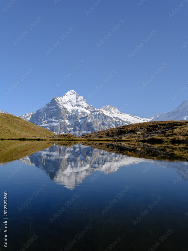 Rocky mountains and reflection on the surface of the lake. Landscape in Grindelwald, Switzerland.