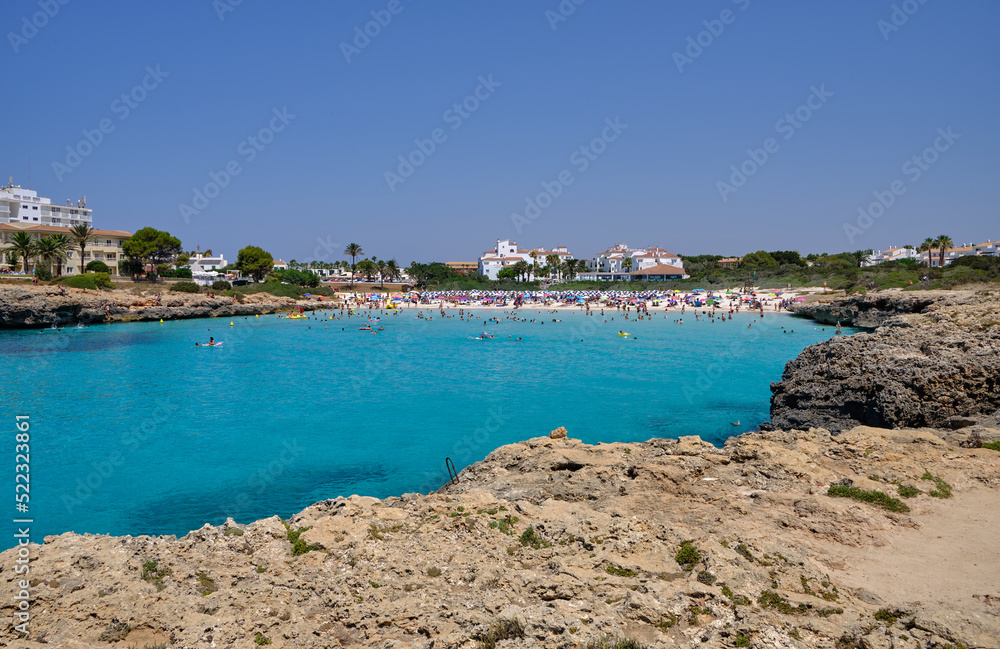 Menorca, Spain: Cala en Bosch beach minorca . Cami de cavalls. Beautiful minorca beach with small hotel in the background. white sand and turquoise water