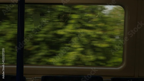 View of houses and trees from train window in outskirts of London, United Kingdom.