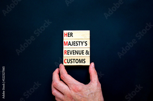 HMRC her majestys revenue and customs symbol. Concept words HMRC her majestys revenue and customs on blocks on beautiful black background. Business HMRC revenue and customs concept. Copy space. photo