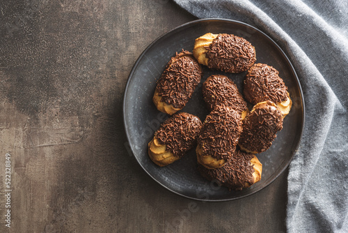Petit fours with chocolate sprinkles. Mini chocolate dessert on plate.