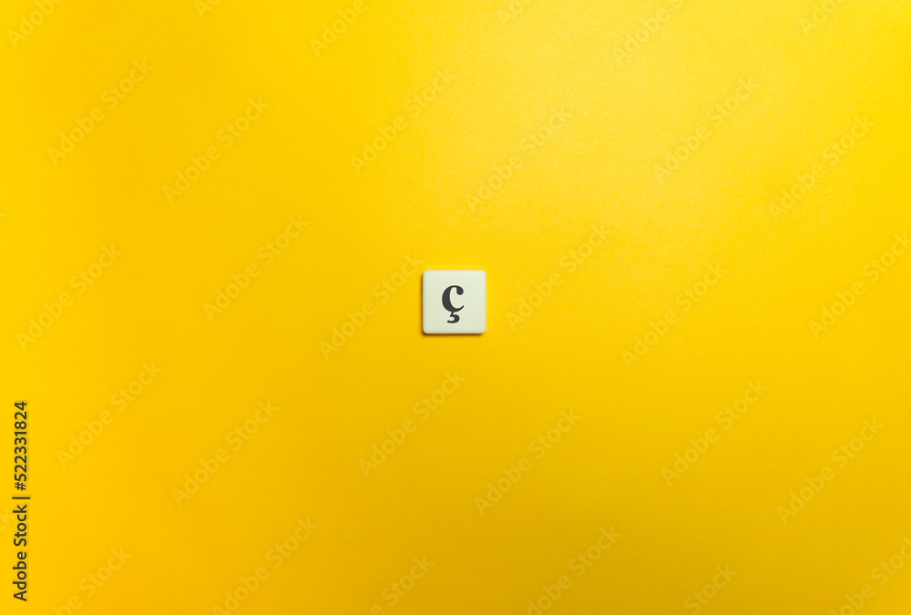 Cedilla Diacritical Mark on Letter Tile on Yellow Background. Minimal Aesthetics. Cedilla Diacritical Mark on Letter Tile on Yellow Background. Minimal Aesthetics.
