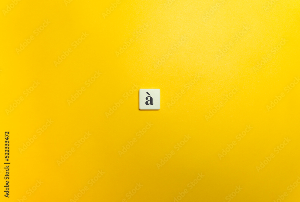 Grave Accent Diacritical Mark on Letter Tile on Yellow Background. Minimal Aesthetics. Grave Accent Diacritical Mark on Letter Tile on Yellow Background. Minimal Aesthetics.