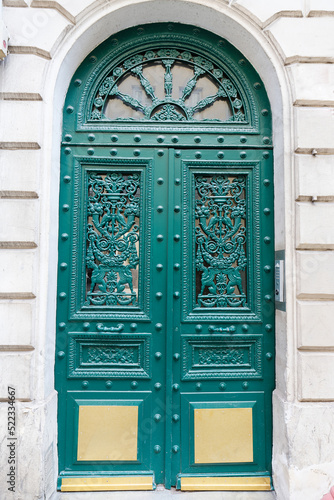 The rich decor decorates an entrance door of the old building of traditional architecture of in downtown, Paris.