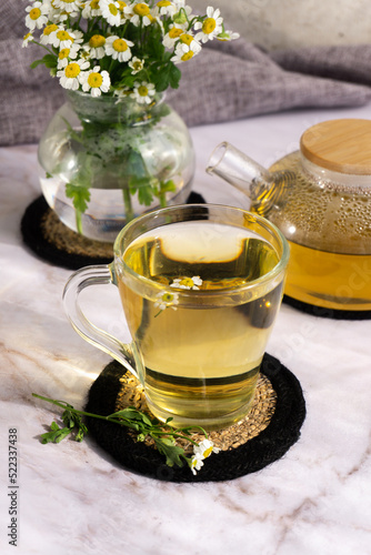 Chamomile tea. Herbal tea. Glass cup with warm fragrant chamomile tea