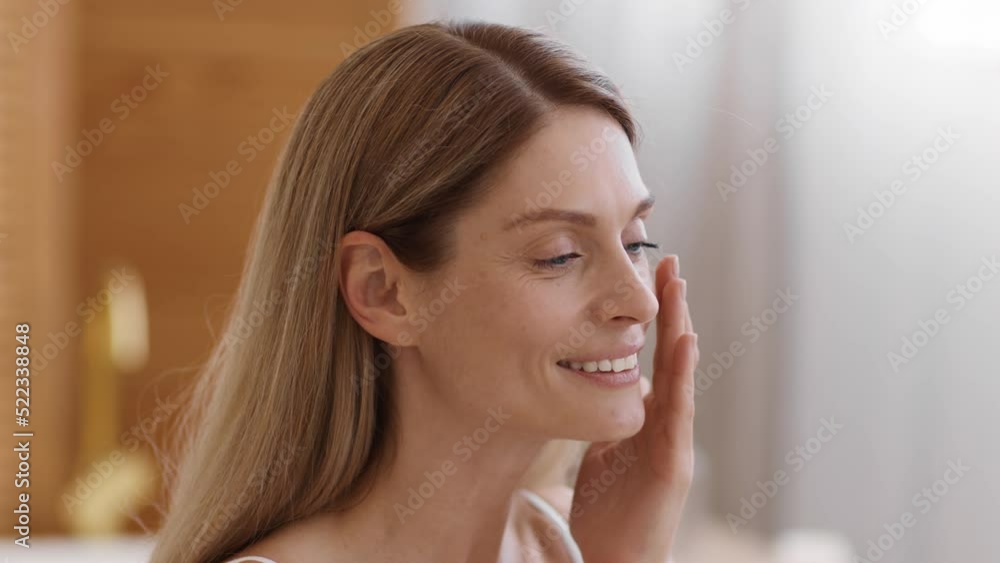 Natural beauty. Close up portrait of beautiful middle aged lady touching her face, enjoying her smooth skin, free space Natural beauty. Close up portrait of beautiful middle aged lady touching her face, enjoying her smooth skin, free space