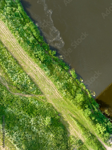 Top view of a wide river and green spaces. Shooting nature from a drone in the daytime on a bright sunny day.