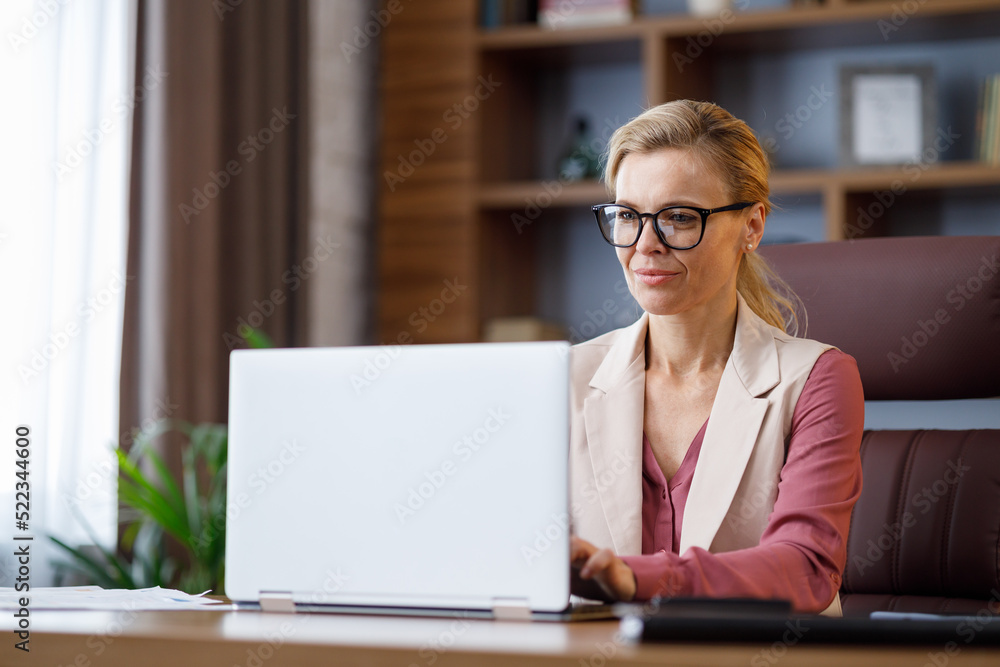 Portrait of beautiful businesswoman working with laptop at office. Texting messages, browsing internet, studying online, remote working. Business concept. Portrait of modern successful female leader Portrait of beautiful businesswoman working with laptop at office. Texting messages, browsing internet, studying online, remote working. Business concept. Portrait of modern successful female leader