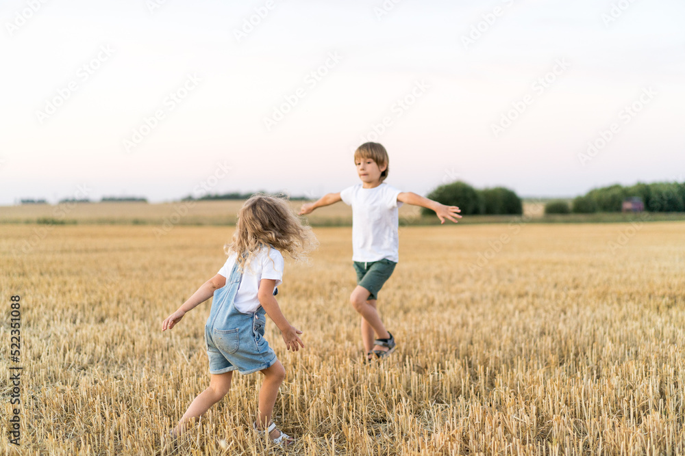 Happy and free people, children run through the beveled field of wheat Happy and free people, children run through the beveled field of wheat