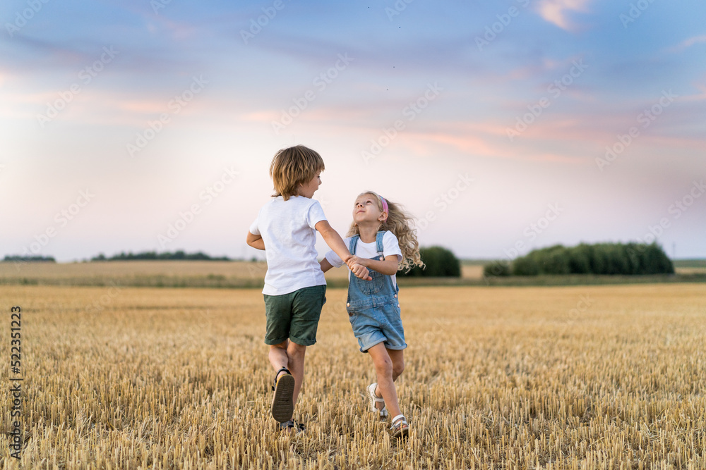 Happy and free people, children run through the beveled field of wheat Happy and free people, children run through the beveled field of wheat