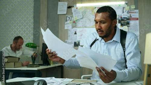 Angry detective reached dead end on investigation. Furious police officer crumples paper and throws away files, unbuttons his shirt and swears. High quality 4k footage