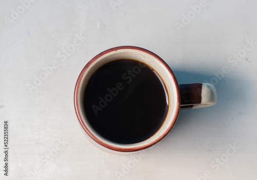 Cup of coffee on white background, view from above