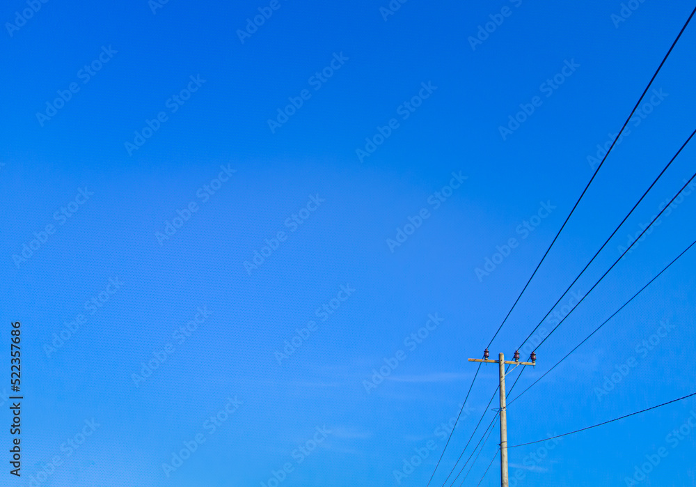 electric pole in a minimalist composition on a bright blue sky with empty space to enter text