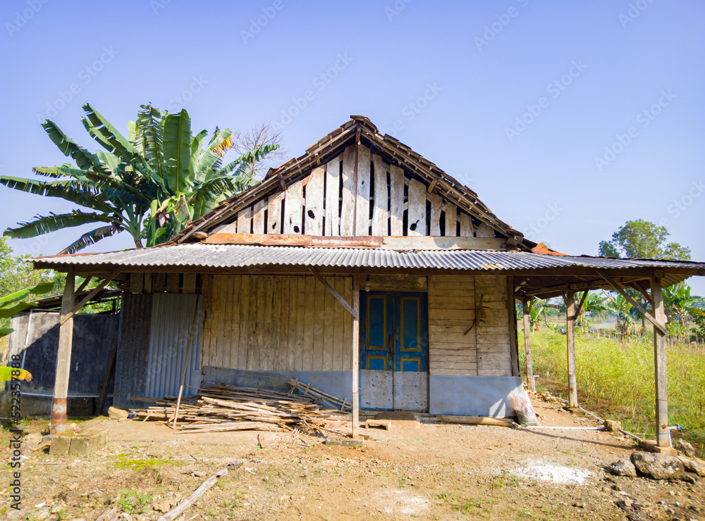 an old wooden house in the fields, a simple wooden house that is no longer inhabited and the dusty dirt yard