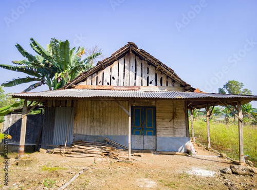 an old wooden house in the fields, a simple wooden house that is no longer inhabited and the dusty dirt yard