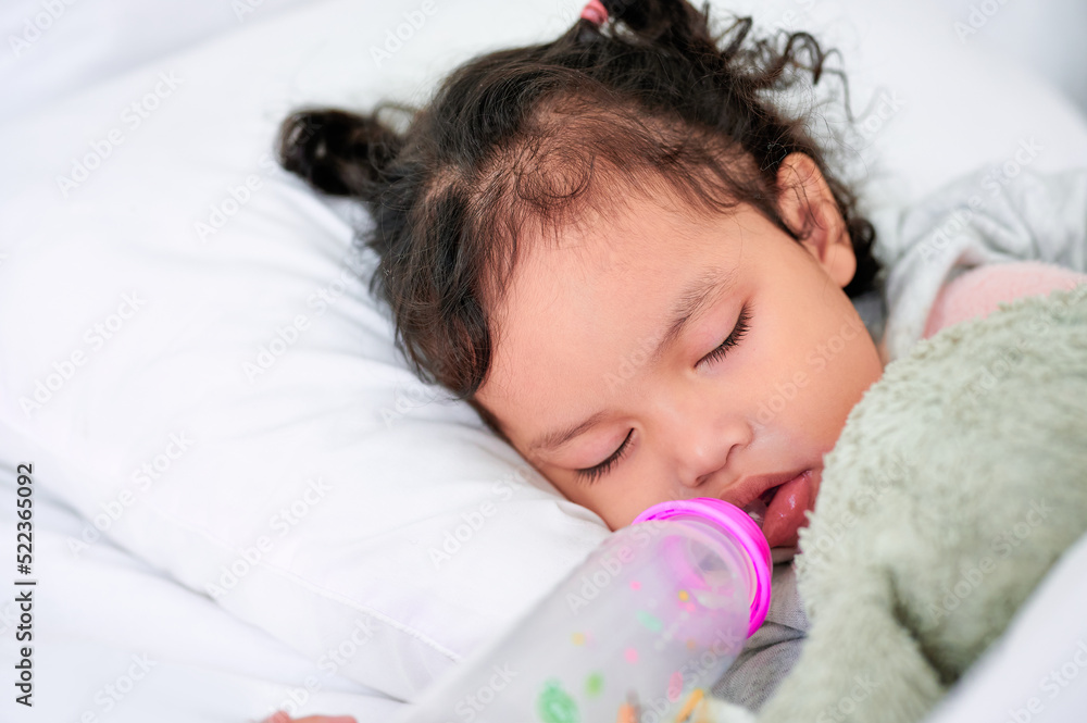 Cute girl sleeping on the mattress with a bottle of milk. Cute girl sleeping on the mattress with a bottle of milk.