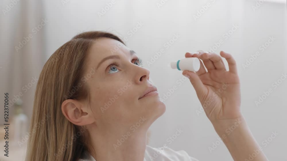 Eyesight cure. Middle aged lady dripping eye drops to eyes and smiling, enjoying clean vision at home, empty space Eyesight cure. Middle aged lady dripping eye drops to eyes and smiling, enjoying clean vision at home, empty space