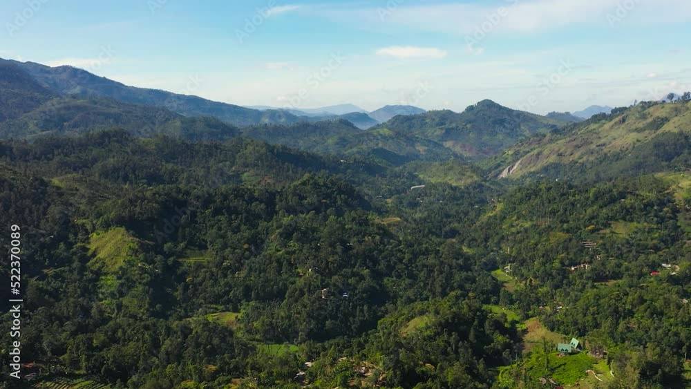 Mountains covered with forest and tropical vegetation against a background of blue sky and clouds. Mountainous terrain in Sri Lanka. Mountains covered with forest and tropical vegetation against a background of blue sky and clouds. Mountainous terrain in Sri Lanka.