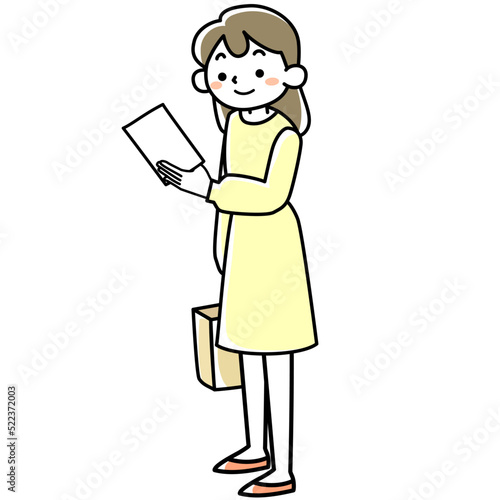 立ったまま手にした紙を見る若い女性