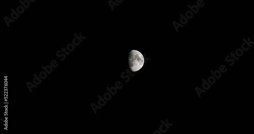 Half a Moon in the Darkness of Space High Above in the Night Sky photo