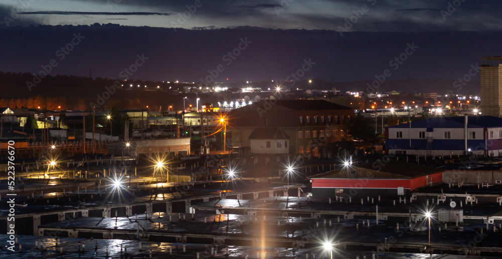 Beautiful night landscape garages stand in rows and a lantern that illuminates them. Night city landscape. There are noises in the photo