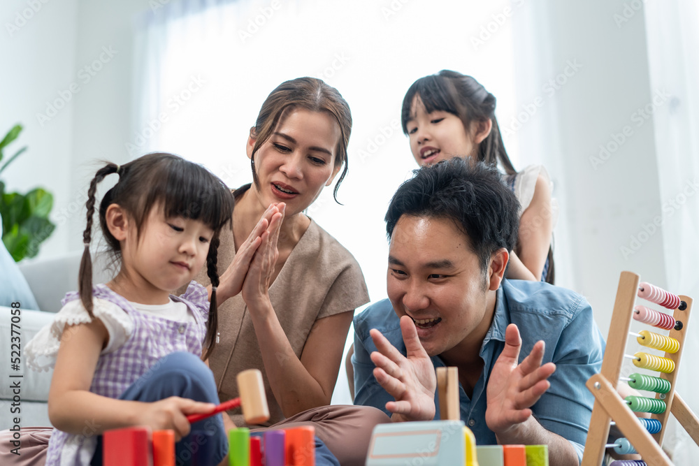 Asian beautiful parent playing education game with daughter in house. Asian beautiful parent playing education game with daughter in house.