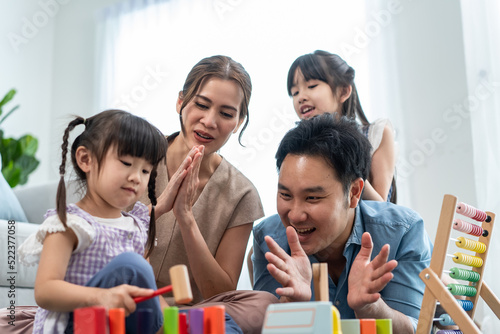 Asian beautiful parent playing education game with daughter in house. 