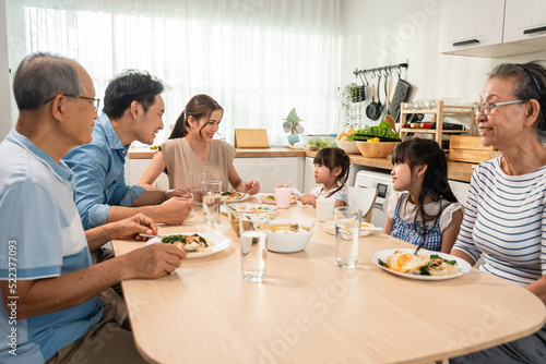 Asian big happy family have lunch on eating table together in house. 