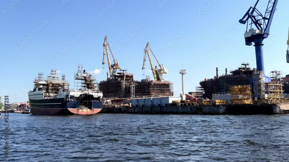 View from sea, offshore shipyards large commercial ships under construction, cranes, dry dock, offshore platform, blue green sea, blue sky with cloud.Engineering and mechanical engineering concept View from sea, offshore shipyards large commercial ships under construction, cranes, dry dock, offshore platform, blue green sea, blue sky with cloud.Engineering and mechanical engineering concept