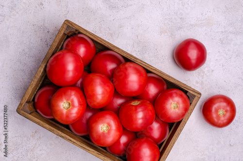 Large raw red tomatoes in a wooden box