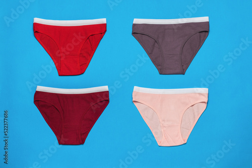 Four colored sports women's panties on a blue background. Minimal concept of women's underwear.