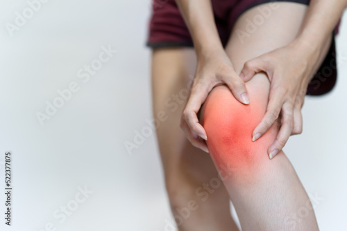 A woman's hand touches her knee due to pain. photo