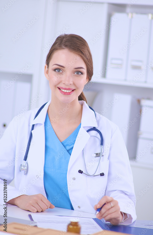 Female doctor sitting on the desk and working a laptop Female doctor sitting on the desk and working a laptop