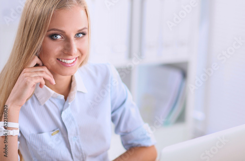 Portrait of beautiful young business woman working on a laptop