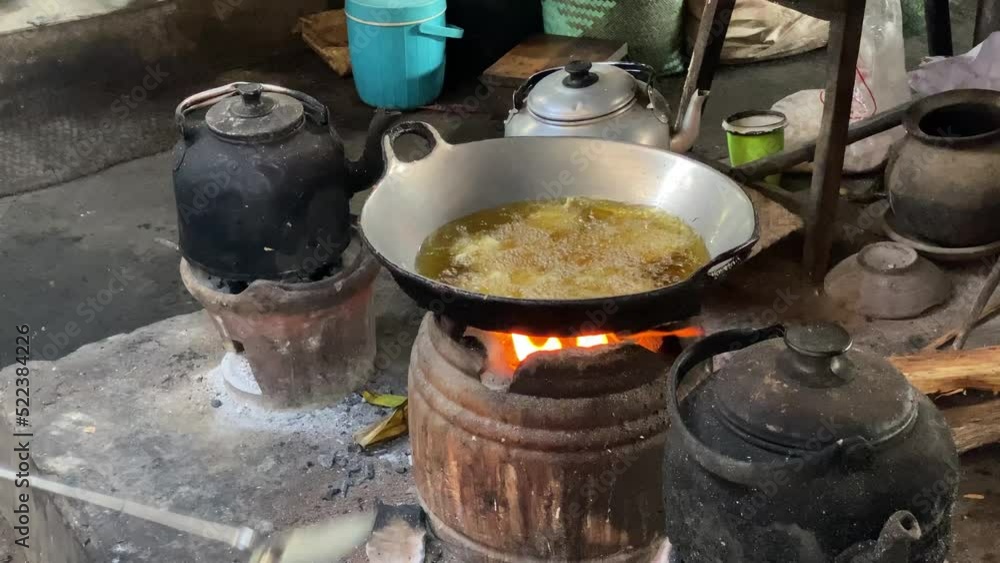 The process of cooking fried foods such as tofu, tempeh (mendoan) in a traditional skillet and stove using coals and a stove. The process of cooking fried foods such as tofu, tempeh (mendoan) in a traditional skillet and stove using coals and a stove.