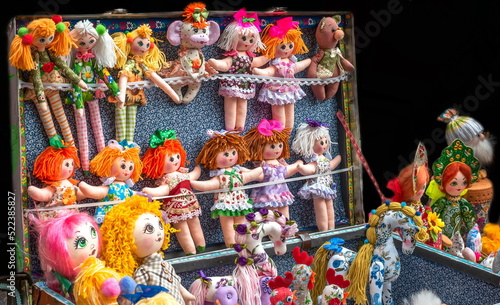 toy homemade rag dolls in a suitcase at the market